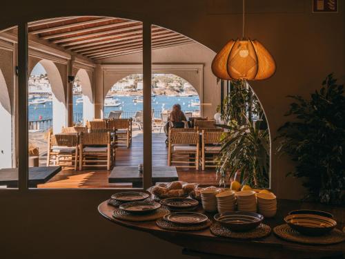 a table with plates of food on it in a restaurant at Hotel Llane Petit in Cadaqués