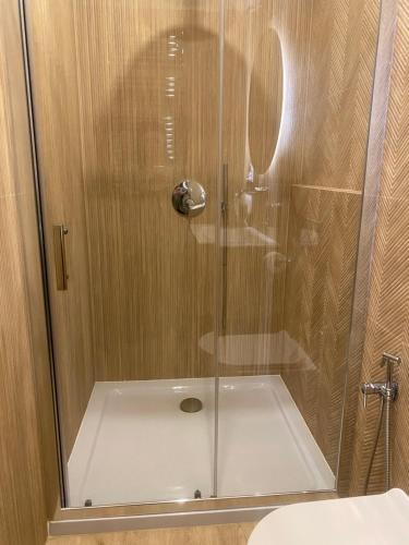 a shower with a glass door in a bathroom at Komfortowy Apartament Rodzinny Forest&Sea lllA in Świnoujście