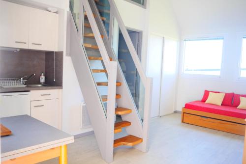 eine Treppe in einer winzigen Küche mit einer roten Couch in der Unterkunft Résidence Simone Lévy - Rêves de mer in Trébeurden