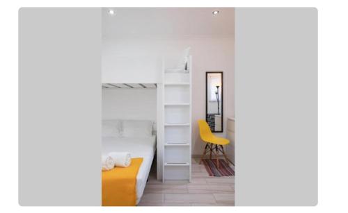 ein Schlafzimmer mit einem Etagenbett und einem gelben Stuhl in der Unterkunft BeGuest Casetta Cleo in Albufeira