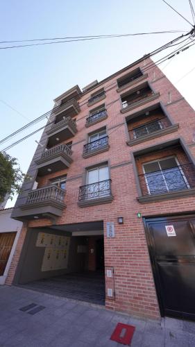 een hoog bakstenen gebouw met ramen en een garage bij Departamento nuevo, luminoso y completo en Salta Vista al Cerro in Salta
