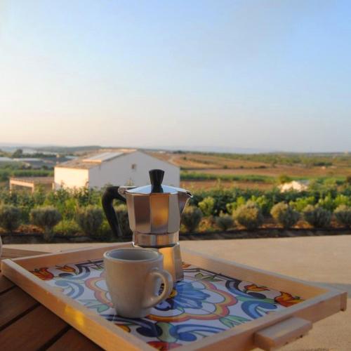 a coffee pot and a cup sitting on a table at Kapuhala Sicily in Marzamemi