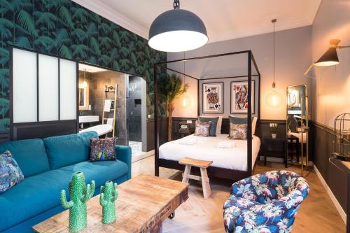 The Royal Elysée Suite في باريس: غرفة معيشة مع أريكة زرقاء وسرير