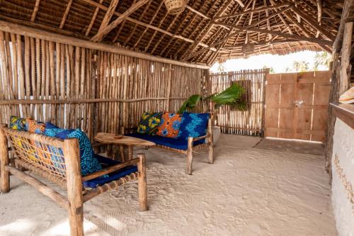 a living room with two chairs and a table at Mamamapambo Boutique Hotel in Jambiani