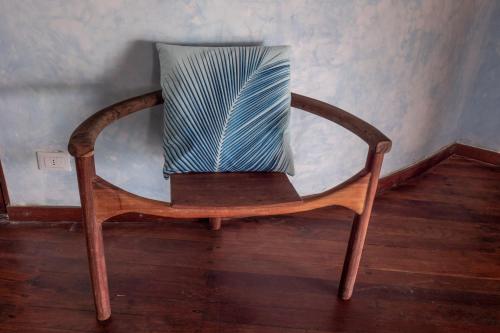 a wooden chair with a pillow on top of it at Mamamapambo Boutique Hotel in Jambiani
