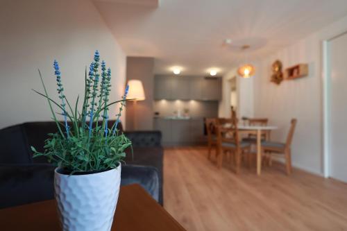 a living room with a vase with a plant on a table at KoBi Apartments Falkenplatz in Luzern