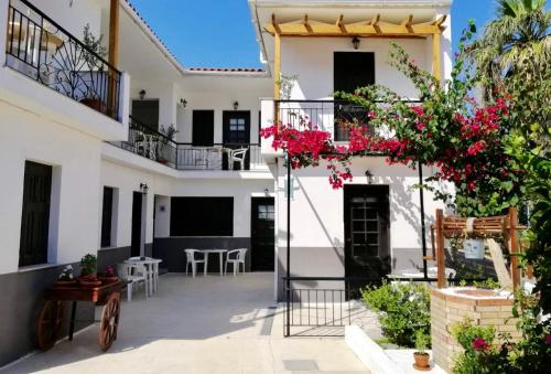 un cortile di una casa con fiori rosa di HOKKUM STUDIOS a Kokkari