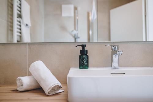 a bathroom sink with a green soap bottle on it at M1 - Mountain Living in Rauris