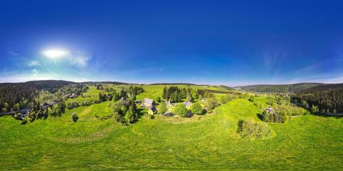 an aerial view of a green hill with houses on it at Berghotel Talblick in Holzhau
