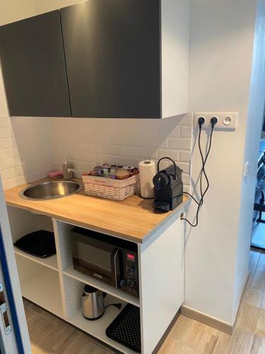 une petite cuisine avec un évier et un comptoir dans l'établissement Le Cosily jacuzzi et sauna privatif, à Cuvilly