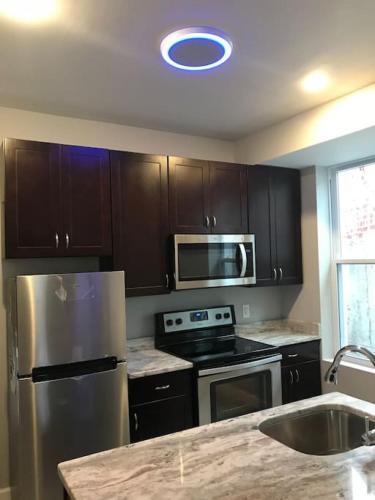 a kitchen with a stainless steel refrigerator and microwave at HOME AWAY HOME - Chic 2 BR Capitol Hill DC in Washington, D.C.