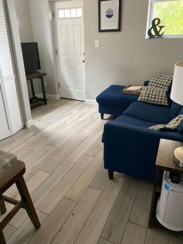 a living room with a blue couch and a wooden floor at HOME AWAY HOME - Chic 2 BR Capitol Hill DC in Washington, D.C.
