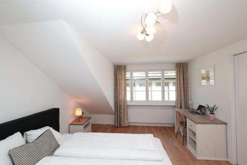 a bedroom with a bed and a desk and a window at KoBi Apartments Falkenplatz in Luzern