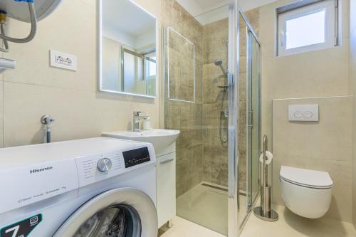 a washing machine in a bathroom with a shower at Apartman Vischetti in Cres