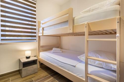 a bedroom with bunk beds in a dorm room at Apartman Vischetti in Cres