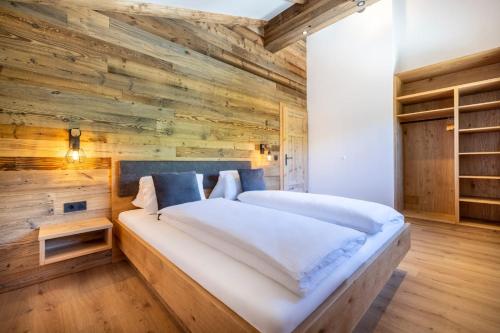 ein Schlafzimmer mit Holzwänden und einem großen Bett in der Unterkunft Almliesl STJO-658 in St. Johann im Pongau