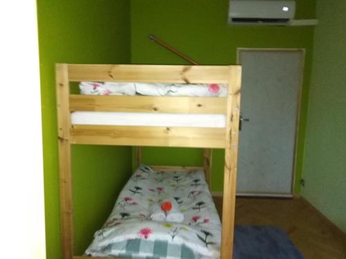 a bunk bed in a room with a green wall at Pokoje Rodzinne Hanna in Gdańsk