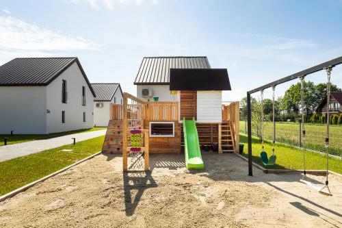 um parque infantil num quintal com uma casa em Komfortowe OH Apartamenty Zator em Zator