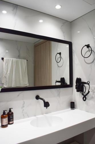 a mirror above a sink in a bathroom at NM Apartments in Mastichari
