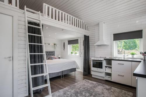 a white bedroom with a bunk bed and a kitchen at Cozy holiday house close to nature in Ödeshög, Gränna in Ödeshög