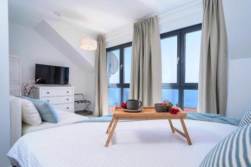 a bedroom with a bed and a table in front of a window at NEW! ReLux Hvar - Remote Luxury Homes in Hvar
