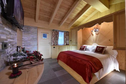 una camera con un grande letto in una baita di tronchi di Il Cuore Del Cervino a Breuil-Cervinia