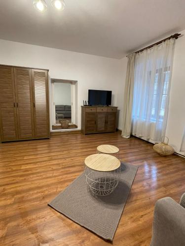 a living room with a wooden floor and a table at Apartament Central Tipografilor in Sibiu