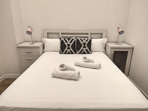 ein Schlafzimmer mit einem großen weißen Bett mit Handtüchern darauf in der Unterkunft Ribera de Córdoba C in Córdoba