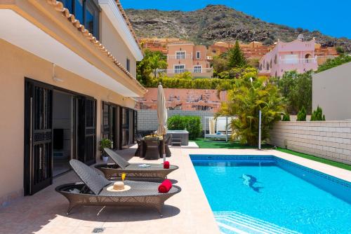 a villa with a swimming pool and a house at TORVISCAS SUNSET VILLA 4 rooms & private Jacuzzi in Adeje