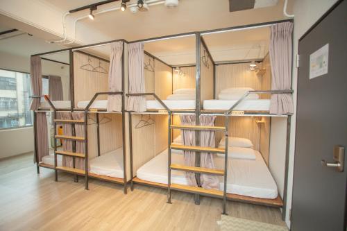 two bunk beds in a room with wooden floors at Corner Hostel & Cafe in Taipei