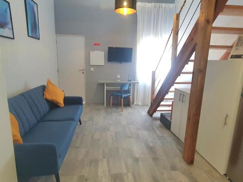 uma sala de estar com um sofá azul e uma escada em Xagi House - Montargil em Montargil