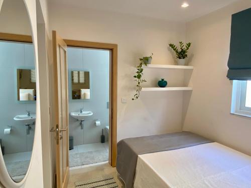 ein kleines Bad mit einem Bett und einem Waschbecken in der Unterkunft Mosta Garden Studio in Mosta
