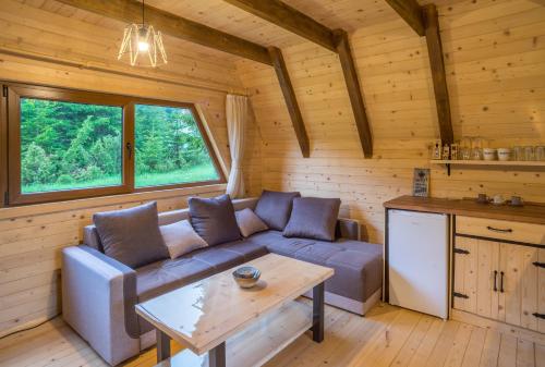 ein Wohnzimmer mit einem Sofa und einem Tisch in der Unterkunft Mountain Houses Emilija in Žabljak