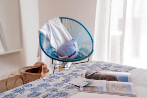 a blue chair sitting next to a bed in a room at Hotel Aubí in Sant Antoni de Calonge