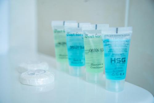 a row of four bottles of just forkiss moisturizers on a counter at Grand Christer Hotel in Kyiv