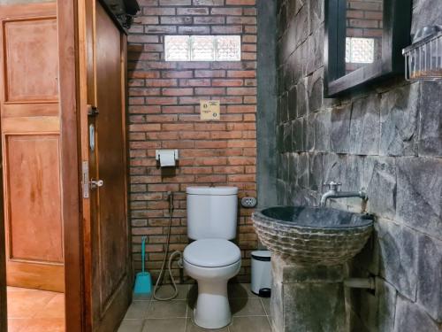 a bathroom with a toilet and a sink at Ndalem Suryo Saptono Guest House in Yogyakarta