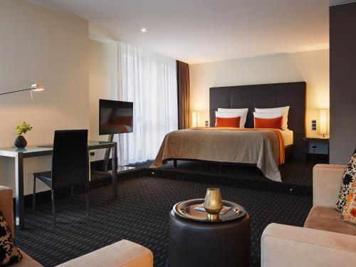 una camera d'albergo con un letto e una scrivania di Boston Hotel HH ad Amburgo