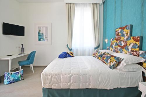 a bedroom with a white bed with a blue wall at Le Camere del Tappezziere in Sant'Agnello