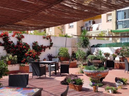 a patio with a table and chairs and potted plants at Hostal LIWI in Barcelona