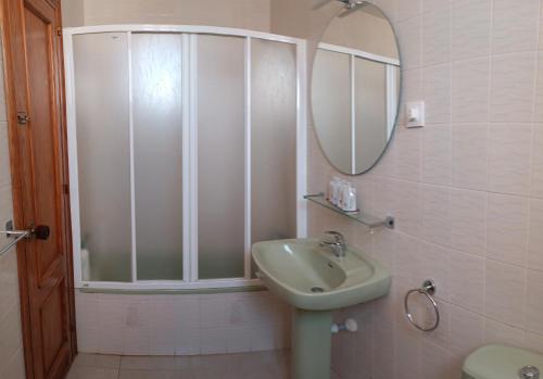 een badkamer met een wastafel en een spiegel bij Casa Iqui in San José