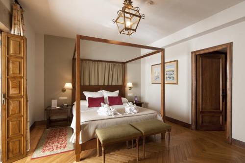 a bedroom with a canopy bed with two stuffed animals on it at Parador de Ribadeo in Ribadeo