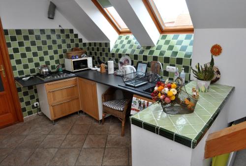 cocina con paredes de azulejos verdes y blancos en Királyszéke Apartman, en Eger