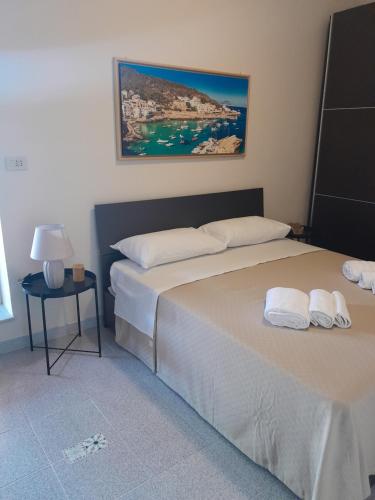 a bedroom with two beds and a side table at Lumera in Santa Flavia