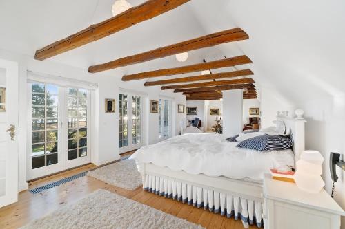 a white bedroom with a large bed and windows at DENMARK SEA FRONT ENCHANTING - Beach Villa in Solrød Strand