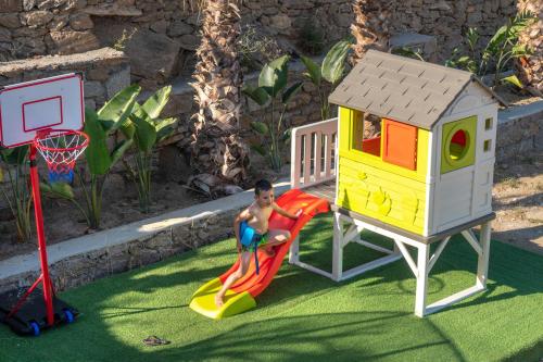 a boy playing on a playground with a play equipment at CORFOS BLUE MYKONOS in Ornos