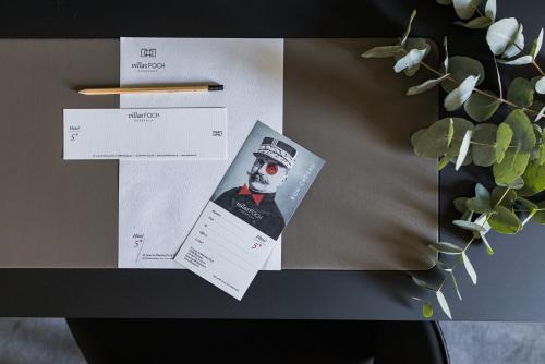 a table topped with two envelopes and aletters at Villas Foch Boutique Hotel & Spa Bordeaux in Bordeaux