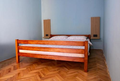 a wooden bed in a room with a wooden floor at Gazdinstvo Tadić in Nikšić