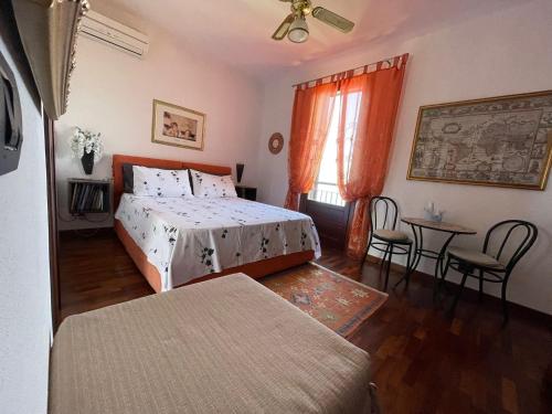 a bedroom with a bed and a table and chairs at B&B Roomantic & Piscina Idromassaggio in Cefalù