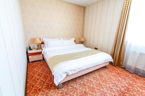 a bedroom with a large bed and a window at Springs Hotel Ulaanbaatar in Ulaanbaatar