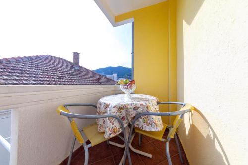 a table and chairs on a balcony with a window at Porta Volta Apartments in Becici